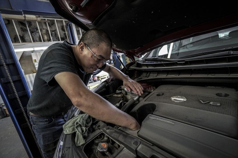 a man checking a NISSAN car engine 