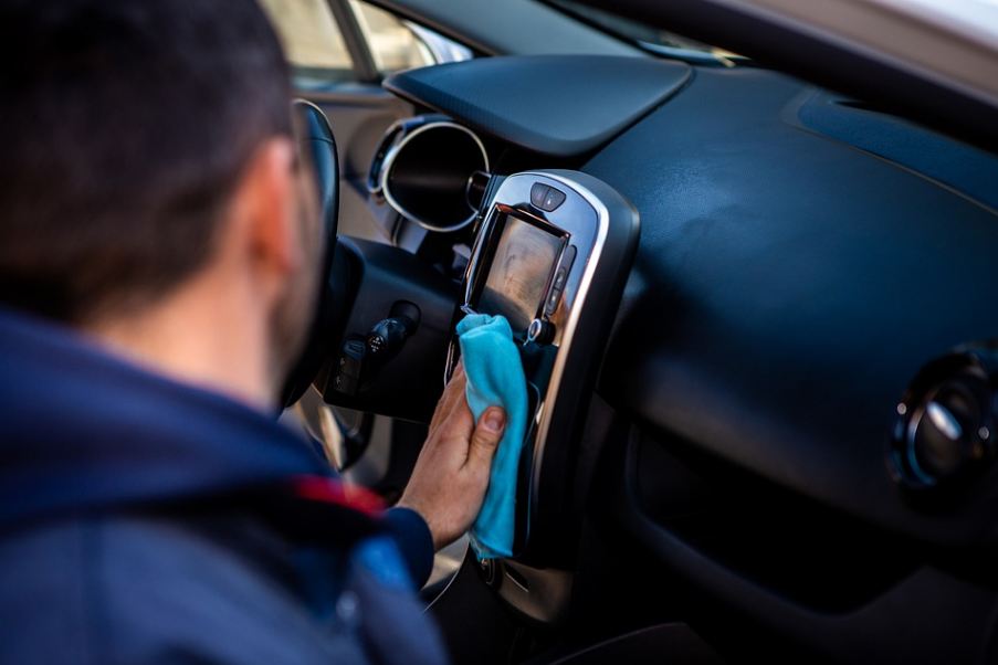 man cleaning the interior of his car