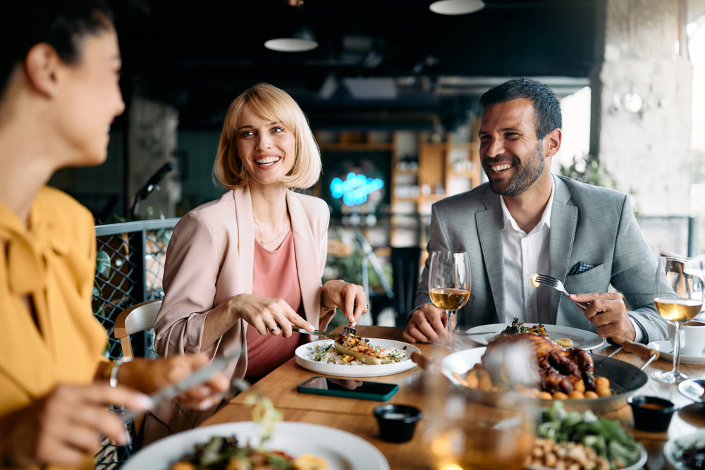Group of happy entrepreneurs communicating while enjoying in business lunch in a restaurant